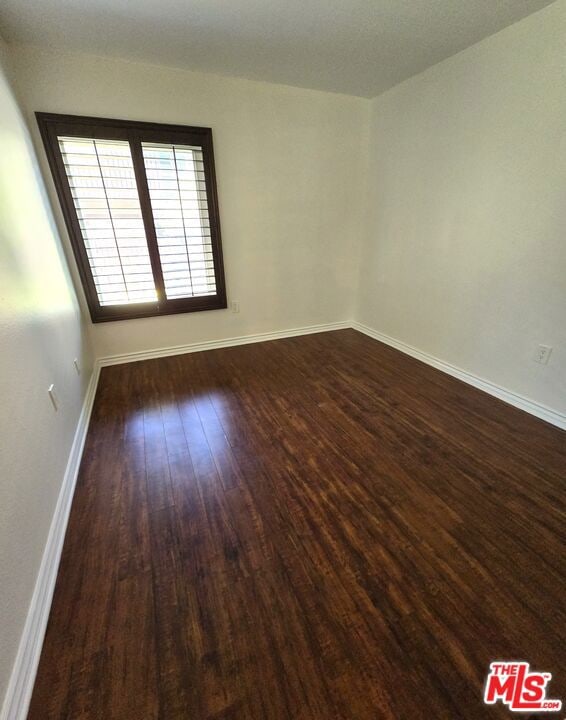 unfurnished room featuring dark hardwood / wood-style flooring