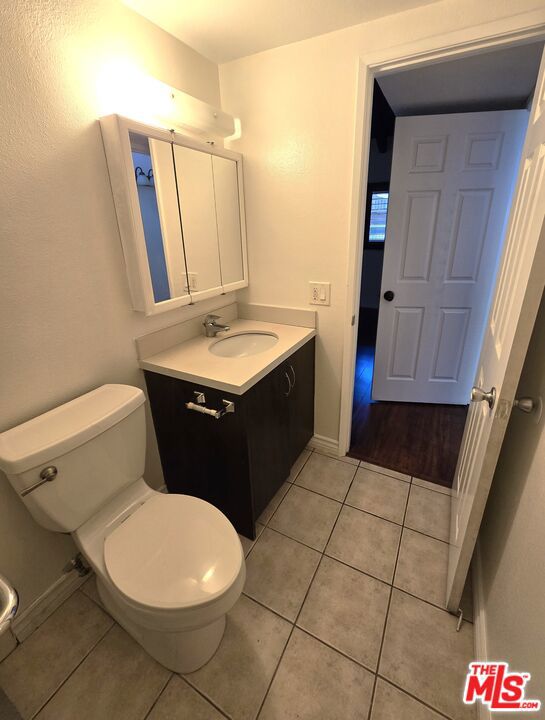 bathroom with vanity, tile patterned flooring, and toilet