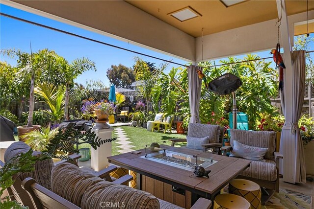 view of patio with an outdoor living space with a fire pit