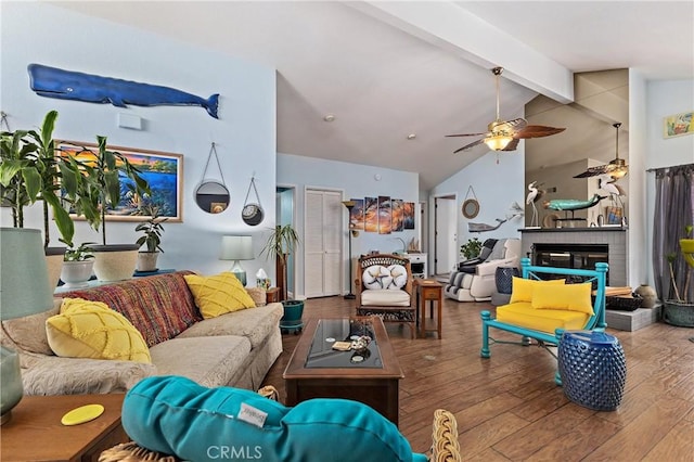 living room with ceiling fan, wood-type flooring, and vaulted ceiling with beams