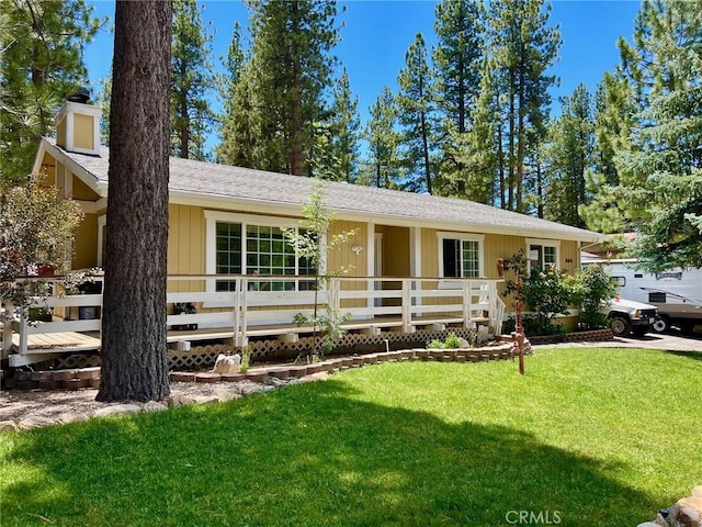 ranch-style house featuring a deck and a front lawn