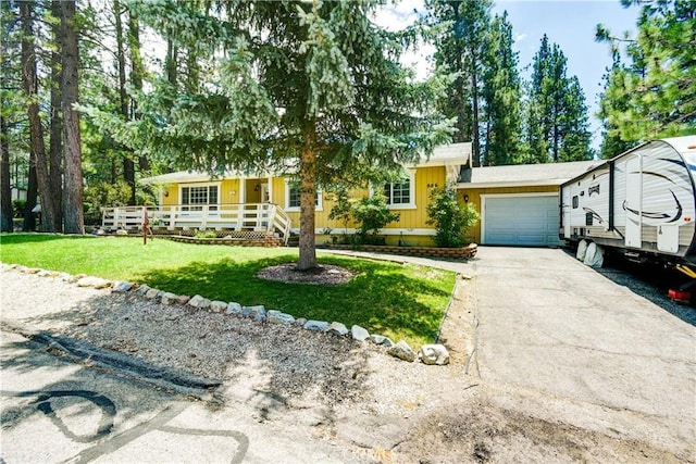 single story home with covered porch, a front yard, and a garage