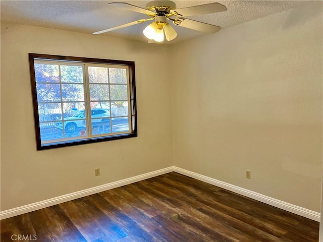 empty room with a textured ceiling, ceiling fan, and dark hardwood / wood-style floors