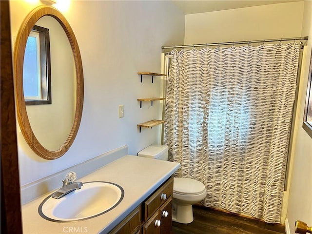 bathroom featuring hardwood / wood-style floors, vanity, toilet, and curtained shower