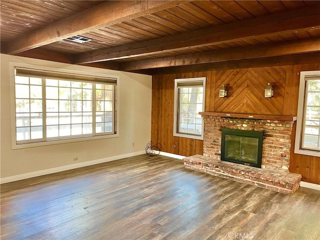 unfurnished living room with plenty of natural light, dark hardwood / wood-style flooring, wooden ceiling, and wooden walls