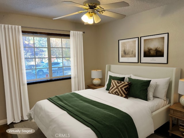 bedroom with ceiling fan and a textured ceiling