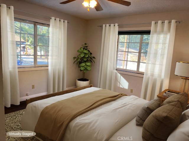 bedroom featuring ceiling fan, wood-type flooring, and a textured ceiling