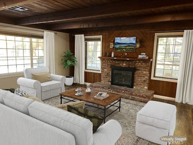 living room featuring a wealth of natural light, a fireplace, wood ceiling, and wood walls