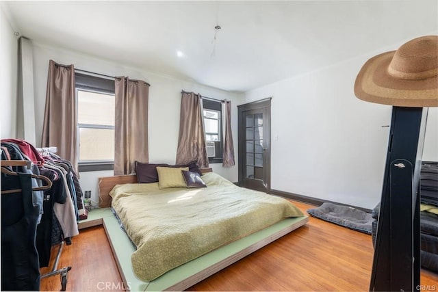 bedroom with hardwood / wood-style flooring and cooling unit