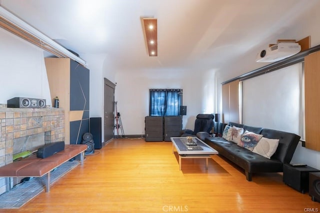 living room with a tiled fireplace and light hardwood / wood-style floors