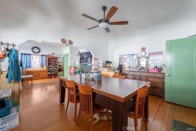 dining area featuring hardwood / wood-style flooring, a textured ceiling, and ceiling fan