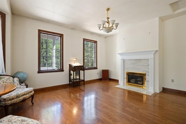 unfurnished room with an inviting chandelier, hardwood / wood-style floors, and a fireplace