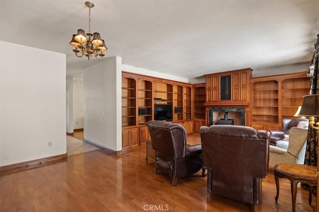 living room with a textured ceiling, an inviting chandelier, and hardwood / wood-style floors