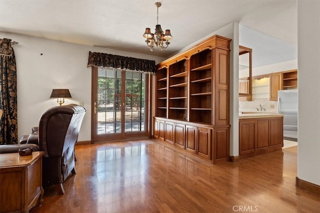 office space featuring a notable chandelier, wood-type flooring, and a textured ceiling