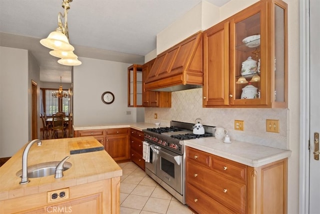 kitchen with light tile patterned floors, an inviting chandelier, pendant lighting, sink, and double oven range