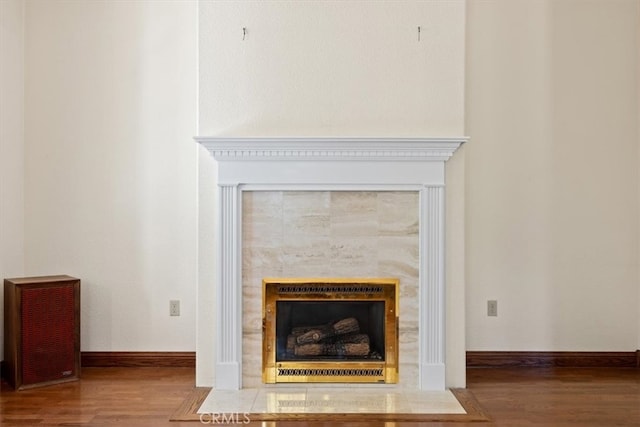 details featuring hardwood / wood-style floors and a tiled fireplace