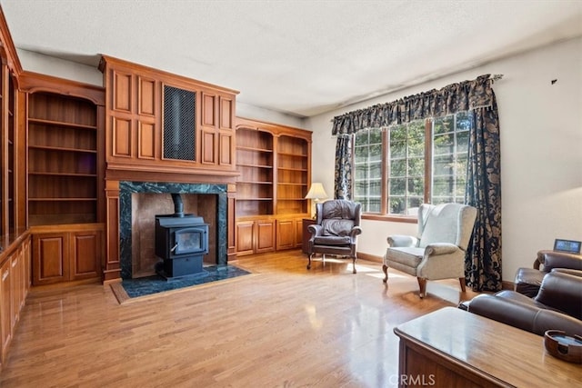 living room featuring a textured ceiling, light wood-type flooring, and a wood stove