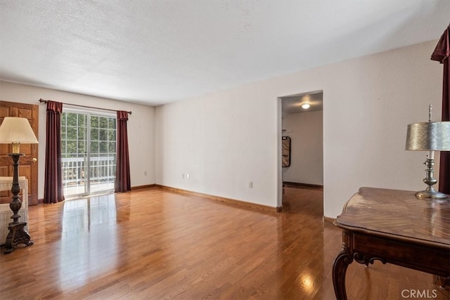 living room featuring a textured ceiling and hardwood / wood-style flooring