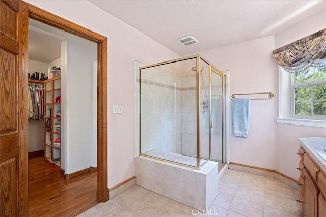 bathroom featuring vanity, hardwood / wood-style floors, and a shower with shower door