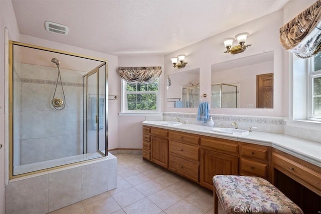 bathroom featuring vanity, an enclosed shower, a textured ceiling, and tile patterned flooring