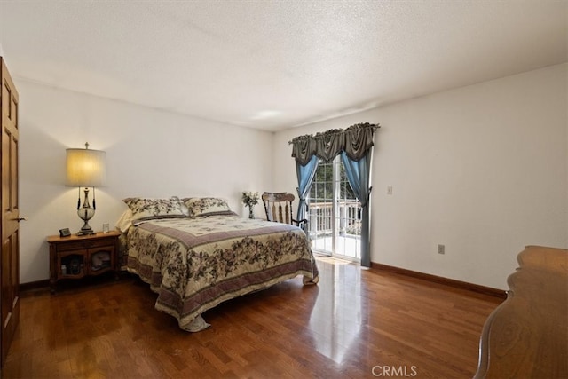 bedroom featuring a textured ceiling, access to exterior, and dark hardwood / wood-style flooring