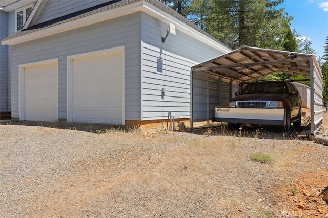 view of side of home featuring a garage and a carport