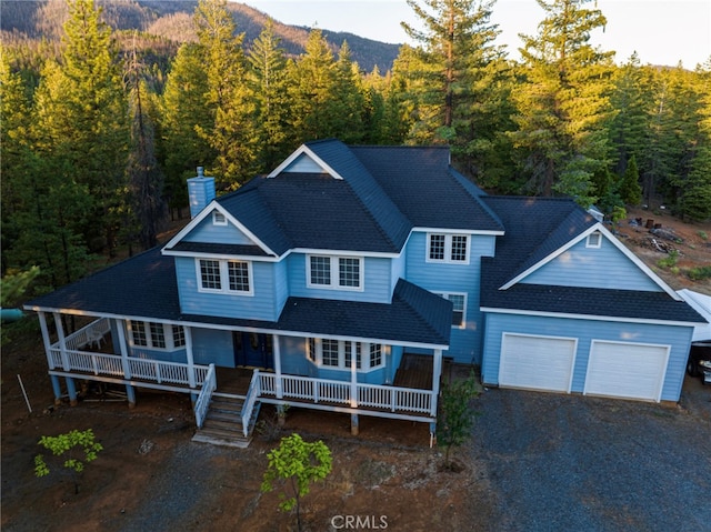 view of front of house with a mountain view, a porch, and a garage