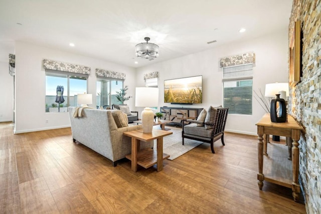 living room with wood-type flooring and a notable chandelier