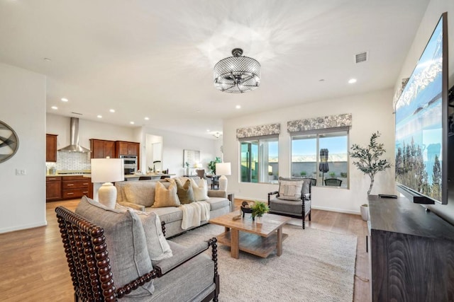 living room featuring a chandelier and light wood-type flooring