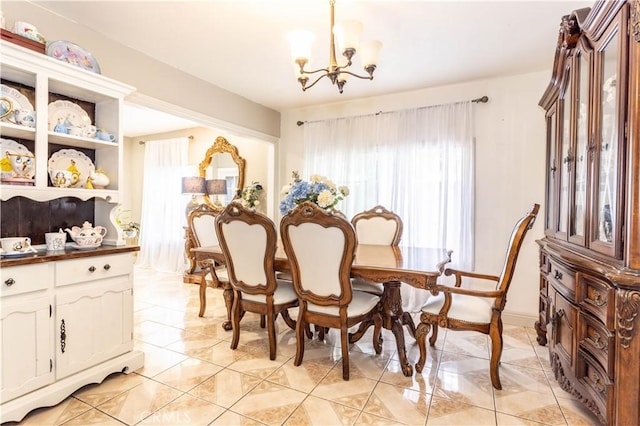 dining area featuring a chandelier and baseboards