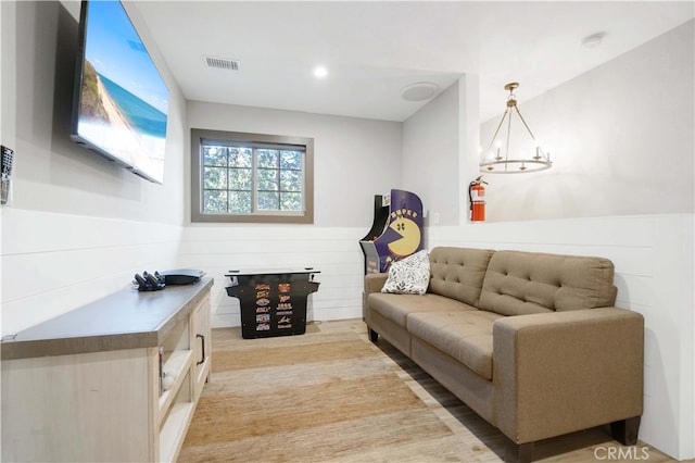 sitting room with light wood-type flooring and a chandelier