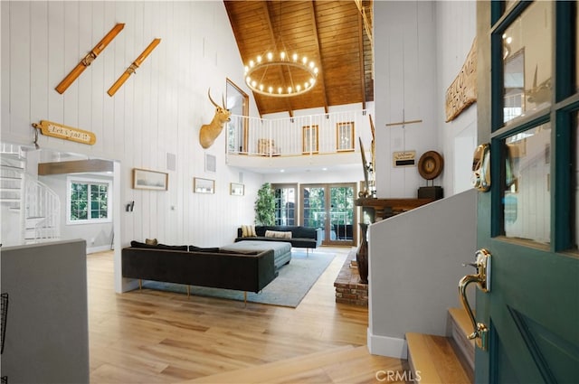 living room with light wood-type flooring, wood ceiling, plenty of natural light, and high vaulted ceiling