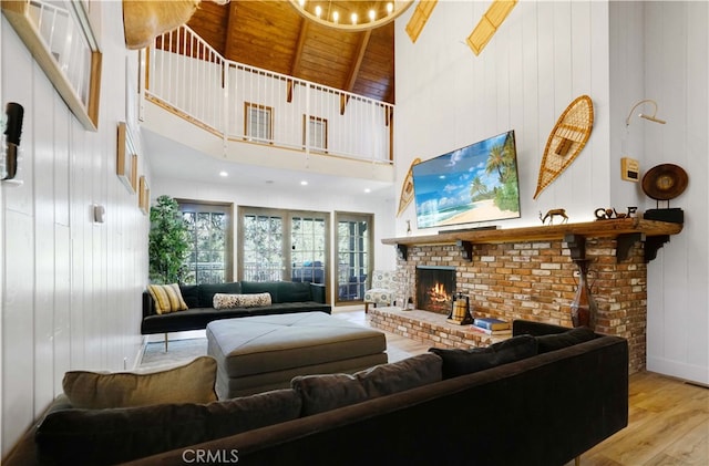 living room featuring wood ceiling, high vaulted ceiling, a fireplace, beam ceiling, and light hardwood / wood-style flooring