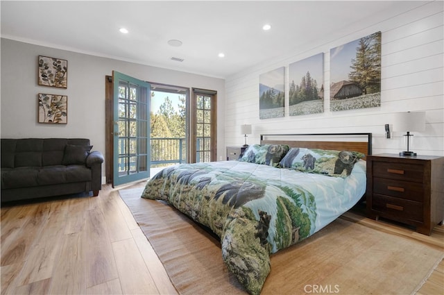 bedroom with light wood-type flooring, crown molding, and access to exterior