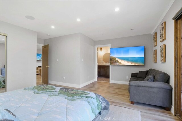 bedroom featuring light wood-type flooring and ensuite bath