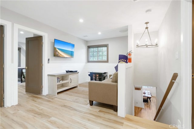 living room with light hardwood / wood-style floors and an inviting chandelier