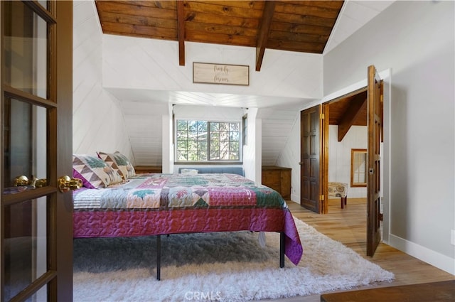 bedroom featuring lofted ceiling with beams, hardwood / wood-style floors, and wooden ceiling