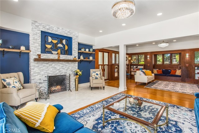 living room featuring a notable chandelier, a fireplace, and hardwood / wood-style flooring