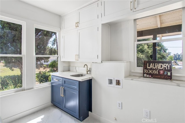 washroom with cabinets, hookup for a washing machine, a healthy amount of sunlight, and sink