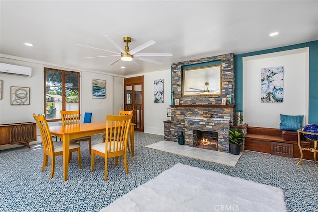 carpeted dining room with a wall unit AC, ceiling fan, and a stone fireplace