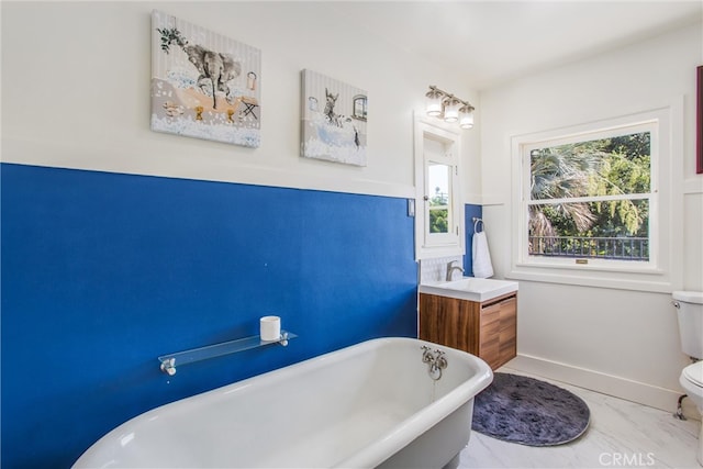 bathroom featuring vanity, a bathtub, and toilet