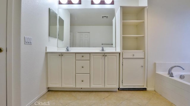 bathroom with a sink, tile patterned floors, double vanity, and tiled bath