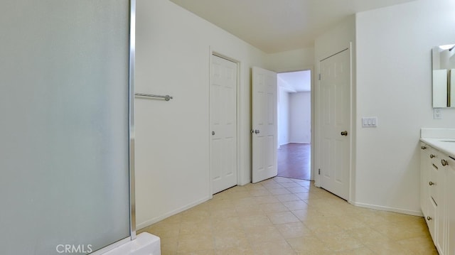 bathroom featuring walk in shower and vanity