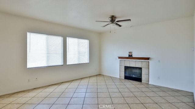 unfurnished living room with ceiling fan, light tile patterned floors, and a tile fireplace