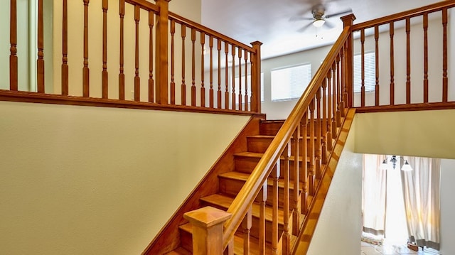 staircase featuring ceiling fan