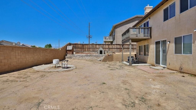 view of yard with a patio area, a balcony, and a fenced backyard
