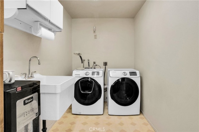 washroom featuring washing machine and clothes dryer and cabinets