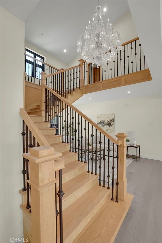 staircase featuring hardwood / wood-style flooring and an inviting chandelier