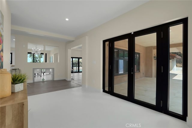 hall featuring french doors and an inviting chandelier