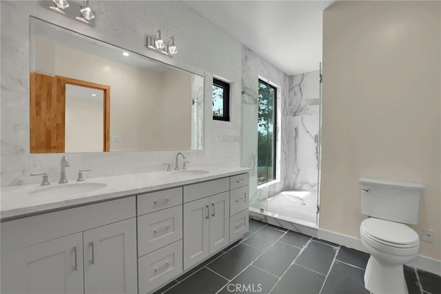 bathroom with tile patterned floors, vanity, tiled shower, and toilet